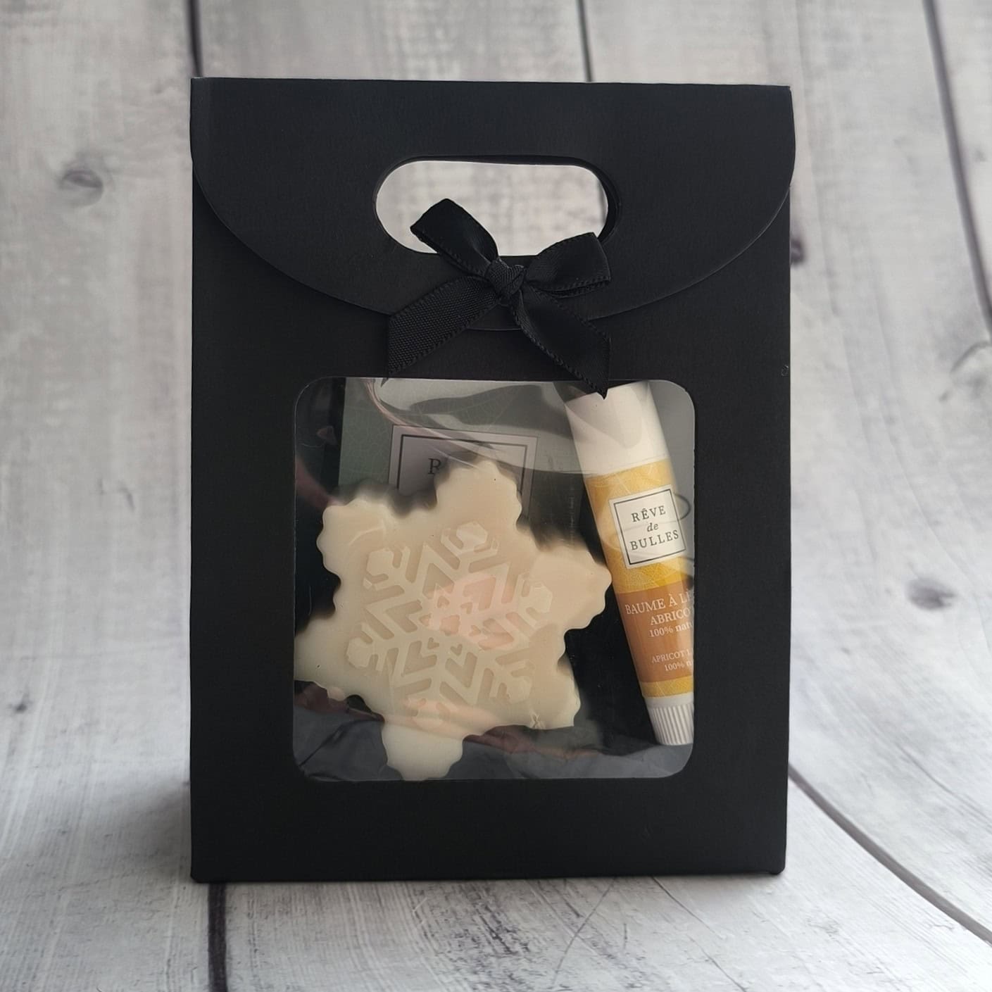 Pochette avec un gros savon flocon et un stick à lèvres abricot